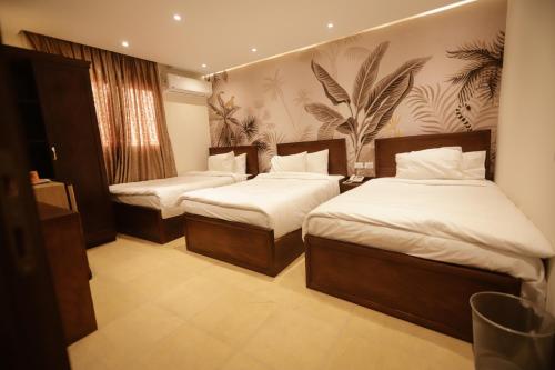 King Khafren View INN في القاهرة: سريرين في غرفة الفندق ذات شراشف بيضاء
