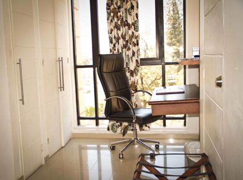 una oficina con silla, escritorio y ventana en Minister Business Hotel, en Tegucigalpa