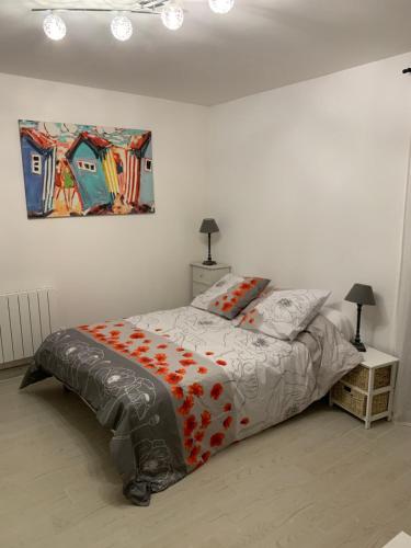 1 dormitorio con 1 cama y una pintura en la pared en résidence KERLOREA studio 6, en Itxassou