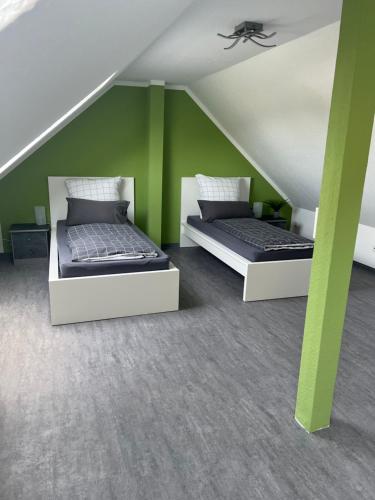 two beds in a room with green walls at Zum Josefstal zwei in Sankt Ingbert