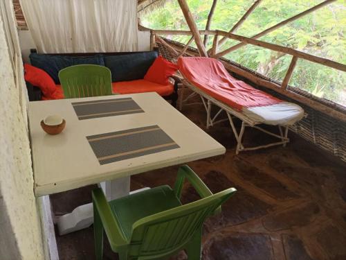 een kamer met een tafel en stoelen en een bank bij Sophia house in Malindi