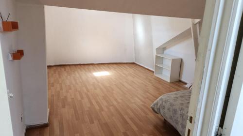 une chambre vide avec un lit et du parquet dans l'établissement CHATEAU JAPY APPARTEMENT DUPLEX NY, à Dasle
