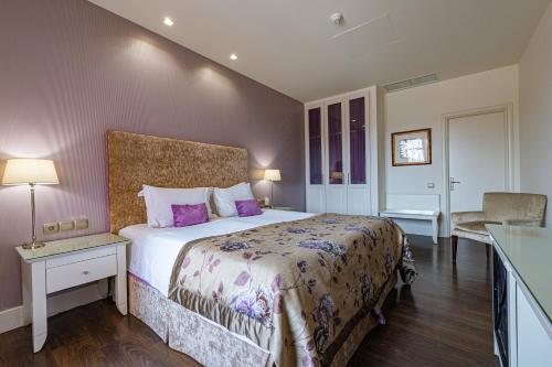 a bedroom with a large bed with purple pillows at Nymfasia Resort in Vytina