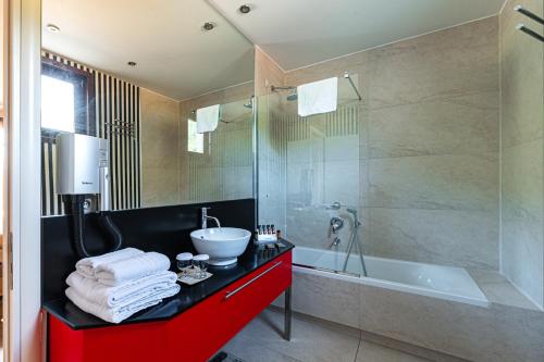 a bathroom with a sink and a shower and a tub at Nymfasia Resort in Vytina