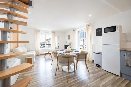 une cuisine avec une table et des chaises dans une pièce dans l'établissement Duplex Petit-Fort Philippe, à Gravelines
