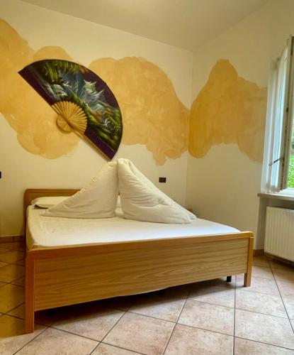 a bedroom with a bed with a painting on the wall at Casa Guarnati Lake View Apartments in Malcesine