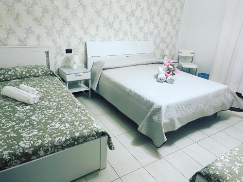 a bedroom with two beds and flowers on a table at B&B Villa Anna in Sibari