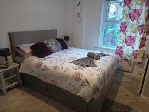 een slaapkamer met een bed en een raam bij Pleasure beach apartment with garden in Skegness