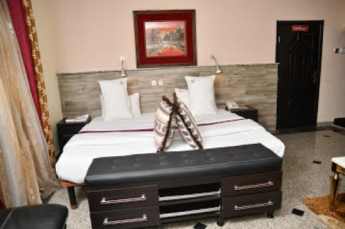 sypialnia z dużym łóżkiem z drewnianym zagłówkiem w obiekcie Room in Lodge - Choice Gate Hotel-Business Double w mieście Benin