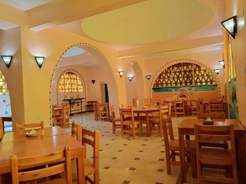 a restaurant with tables and chairs in a room at Hllol Hotel in Abu Simbel