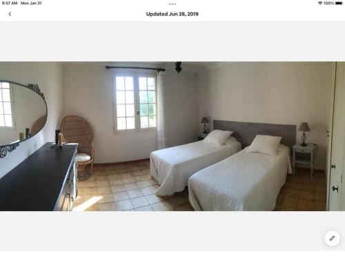 une chambre avec deux lits et un miroir dans l'établissement Petit coin de Paradis en Provence, à Aups