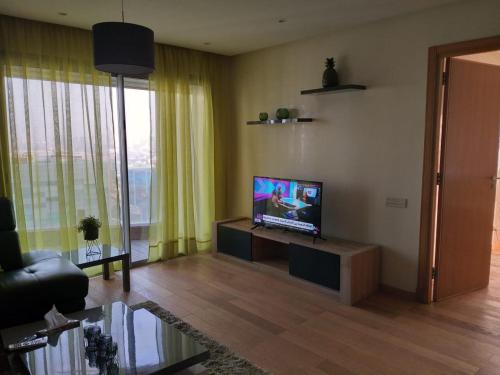a living room with a flat screen tv on a table at Casablanca Marina by Saloua in Casablanca