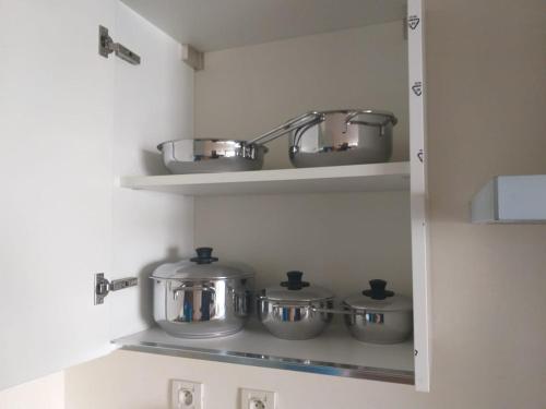 a row of pots and pans on a shelf in a kitchen at Casablanca Marina by Saloua in Casablanca