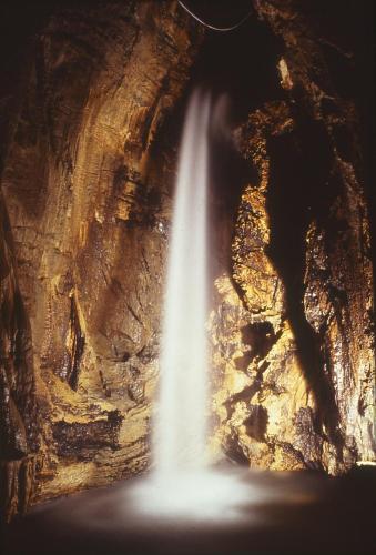 a waterfall in a cave with a waterfall at Agriturismo Bio-Ecologico Sant'Isidoro in Roccaforte Mondovì