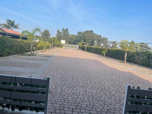 a cobblestone street with two benches in a park at B&B Villa Anna in Sibari