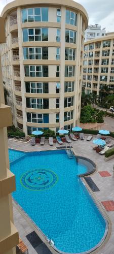 a large swimming pool in front of a large building at City Garden Pattaya - 2br Suite, 76sqm in Pattaya