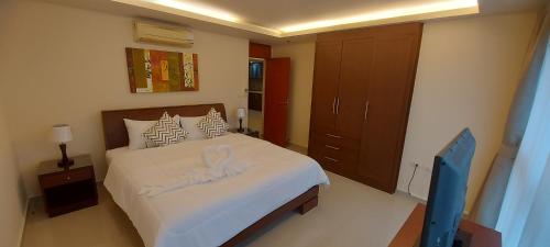 a bedroom with a large bed with white sheets at City Garden Pattaya - 2br Suite, 76sqm in Pattaya Central