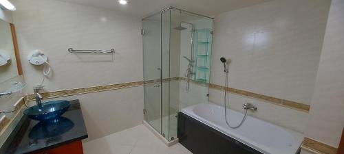 a bathroom with a shower and a tub and a toilet at City Garden Pattaya - 2br Suite, 76sqm in Pattaya