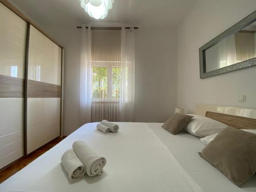 um quarto com uma grande cama branca com toalhas em apartments Marina,Bikić em Marina