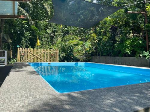 ein blauer Pool in einem Garten mit einem Zaun in der Unterkunft The Twin Studio Cottages 