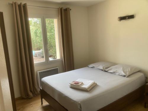 une chambre avec un lit avec deux serviettes dessus dans l'établissement Villa récente avec piscine privée, aux Angles (Gard)