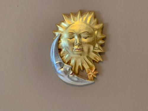 a gold sun and moon wall clock on a wall at B&B MARINA contacless check in in Santa Cristina in Val Gardena
