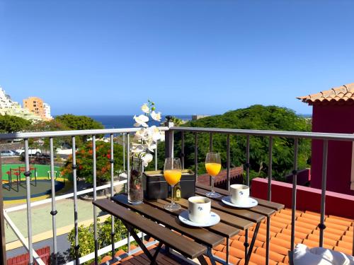 a table with two glasses of wine on a balcony at Las Vistas-Rincón acogedor con vistas al mar in Tabaiba