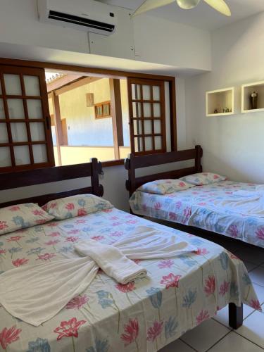 - une chambre avec 2 lits et une fenêtre dans l'établissement Condomínio Solar dos Peixes, à Praia do Forte