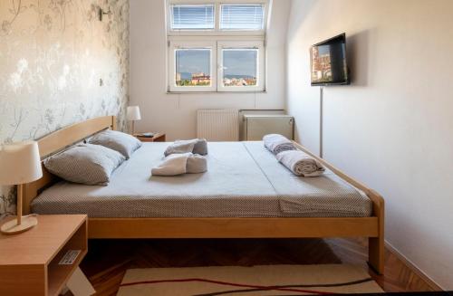 a bedroom with a bed and a window at Apartman Centar in Niš