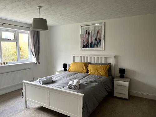 a bedroom with a bed with two shoes on it at Partridge House • Sleeps 9 in Oakham