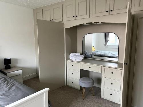 1 dormitorio con tocador con espejo y cama en Partridge House • Sleeps 9 en Oakham