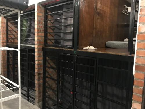 a wine cellar with black doors and a brick wall at OA ThE FACTORY AT BUKIT BINTANG in Kuala Lumpur