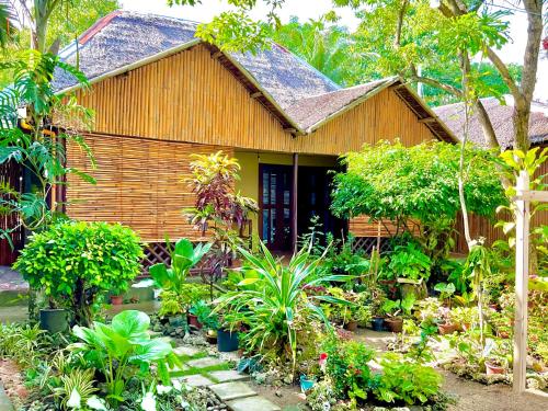a house with a lot of plants in front of it at Treasure Beach Resort in Carles