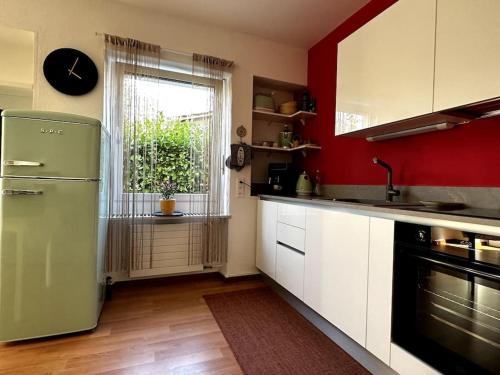 a kitchen with a green refrigerator and a window at Accogliente appartamento con cucina arredata in Ascona