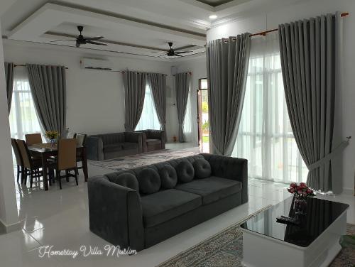a living room with a couch and a table at Homestay Villa Muslim Kuala Terengganu with pool and parking in Kuala Terengganu