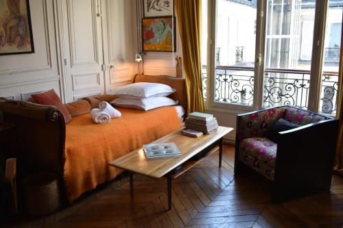 une chambre avec un lit, une table et une chaise dans l'établissement Rue de Paradis, à Paris