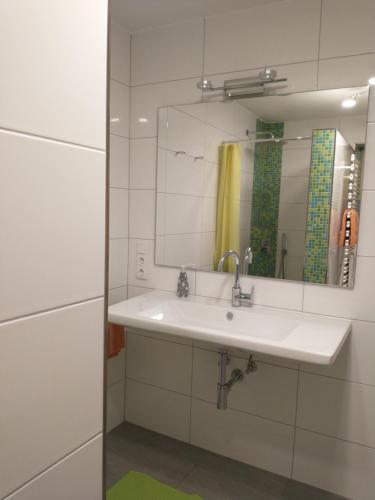 een badkamer met een wastafel en een spiegel bij Ferienhaus Keller in Lippertsreute