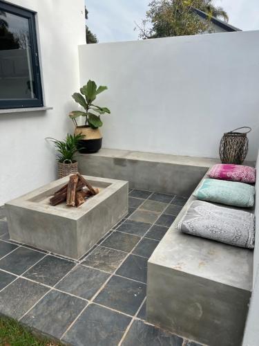 a patio with a fire pit and two pillows at Market on 5 in Piet Retief