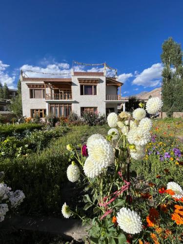 uma casa com flores em frente em Chakzot garden house em Leh