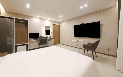 a hotel room with a bed and a flat screen tv at Brown Dot Hotel Sinan in Gwangju