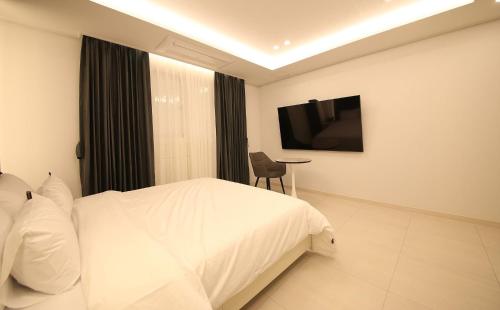a hotel room with a bed and a television at Brown Dot Hotel Sinan in Gwangju