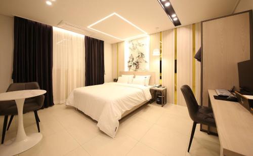 a hotel room with a bed and a desk and a computer at Brown Dot Hotel Sinan in Gwangju