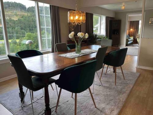 a dining room with a wooden table and chairs at Nakkentunet - familievennlig hus på gårdstun. in Ørskog