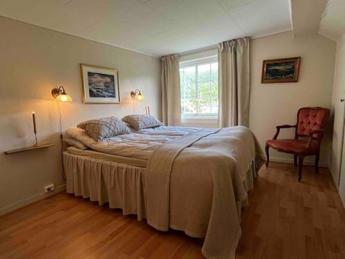 a bedroom with a bed and a chair and a window at Nakkentunet - familievennlig hus på gårdstun. in Ørskog