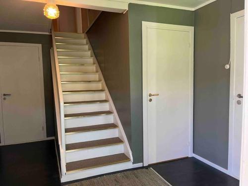 a staircase in a room with green walls at Nakkentunet - familievennlig hus på gårdstun. in Ørskog