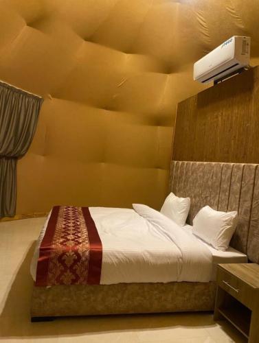 a bedroom with a bed with a projector on the wall at Nara Wadi RUM Camp in Wadi Rum