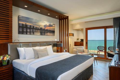 sypialnia z dużym łóżkiem i widokiem na ocean w obiekcie Carlton Tel Aviv Hotel – Luxury on the Beach w Tel Awiwie