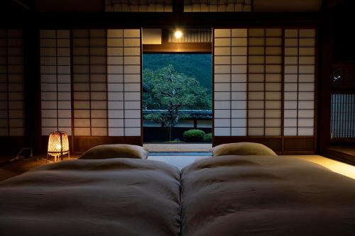 Pokój z łóżkiem i dużym oknem w obiekcie Casa Miyama w mieście Nantan city