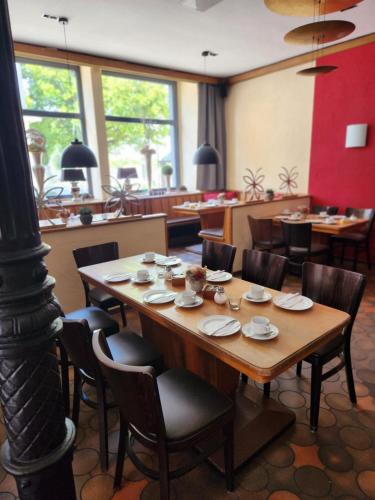 Hotel Hoppe في فيتن: غرفة طعام مع طاولة وكراسي خشبية