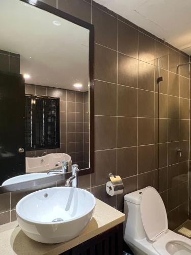 a bathroom with a sink and a toilet and a mirror at Studio 7 Gold Coast Morib Resort in Banting